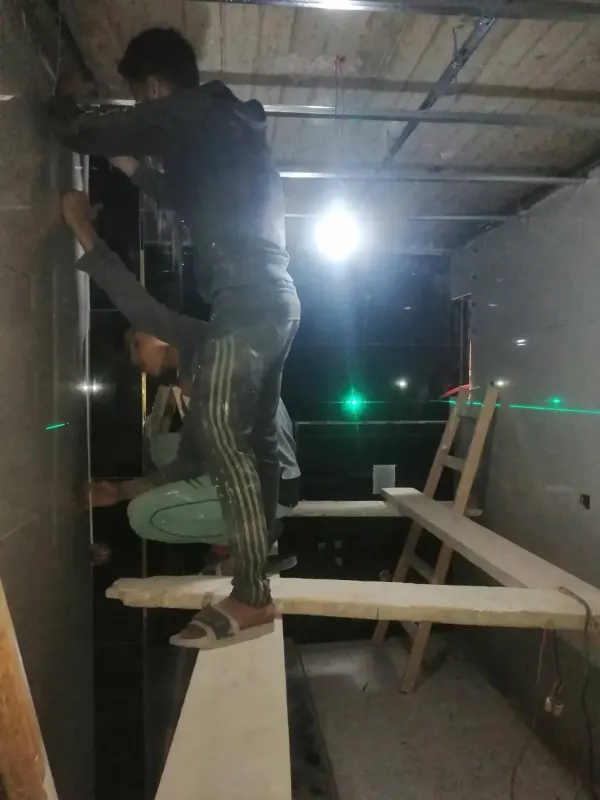 فنيين كريشن بيظبطوا مستوى السقف بميزان الليزر أثناء التشطيب